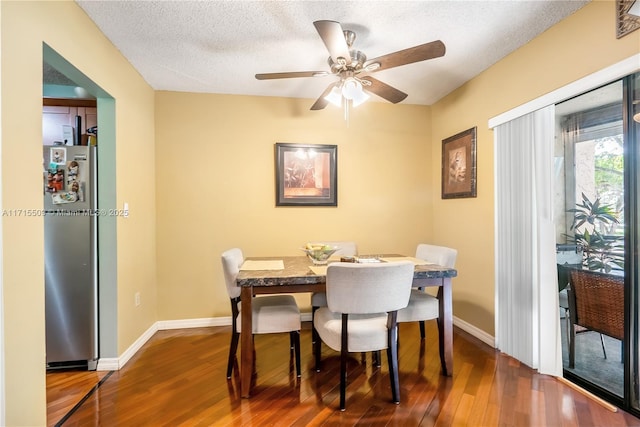 dining room featuring a textured ceiling, dark hardwood / wood-style flooring, and ceiling fan