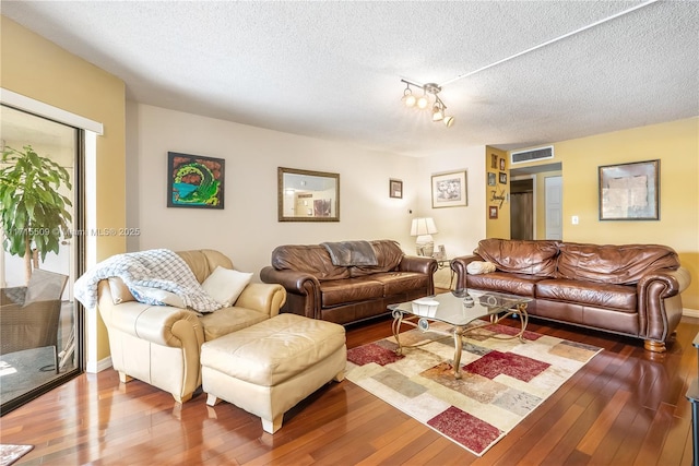 living room featuring wood-type flooring and a textured ceiling