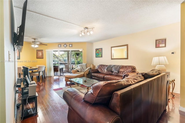 living room with ceiling fan with notable chandelier, a textured ceiling, and dark hardwood / wood-style floors