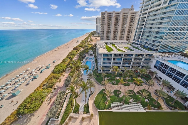 birds eye view of property featuring a water view and a beach view