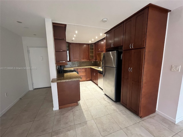 kitchen with tasteful backsplash, dark stone countertops, light tile patterned floors, and appliances with stainless steel finishes