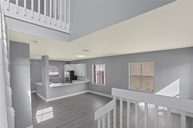 interior space with wood-type flooring and a towering ceiling