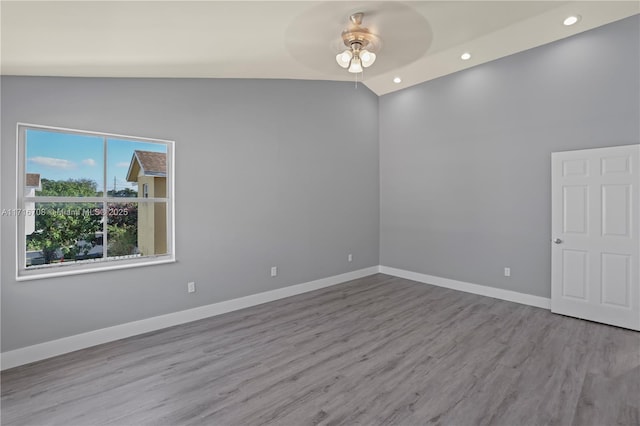 spare room with vaulted ceiling, light hardwood / wood-style floors, and ceiling fan