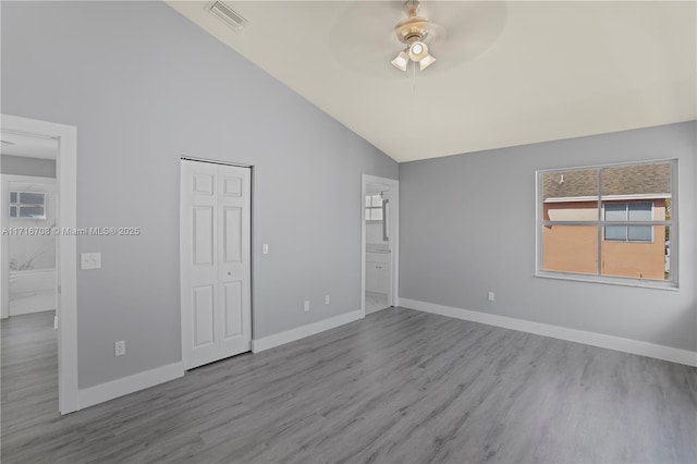 empty room featuring ceiling fan, high vaulted ceiling, and light wood-type flooring