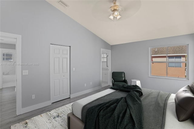 bedroom featuring wood-type flooring, ensuite bathroom, ceiling fan, and high vaulted ceiling