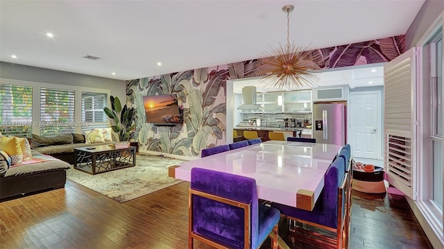 kitchen featuring stainless steel refrigerator with ice dispenser, a kitchen island, tasteful backsplash, island range hood, and dark hardwood / wood-style flooring