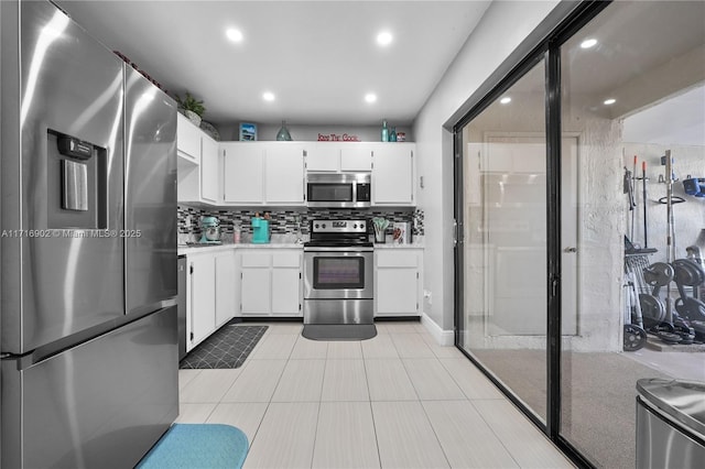 kitchen with white cabinets, decorative backsplash, and stainless steel appliances