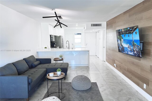 kitchen featuring sink, dark tile patterned floors, kitchen peninsula, white cabinets, and appliances with stainless steel finishes