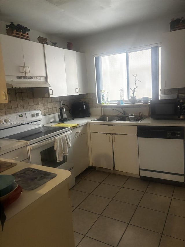 kitchen featuring white cabinetry, electric range, sink, white dishwasher, and light tile patterned floors