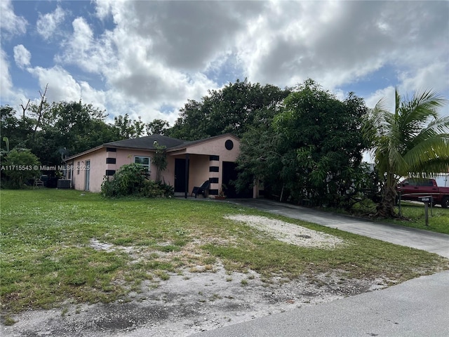 view of front of property with central AC unit and a front lawn