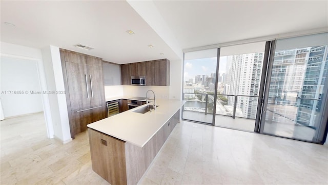 kitchen featuring sink, floor to ceiling windows, wine cooler, light hardwood / wood-style floors, and kitchen peninsula