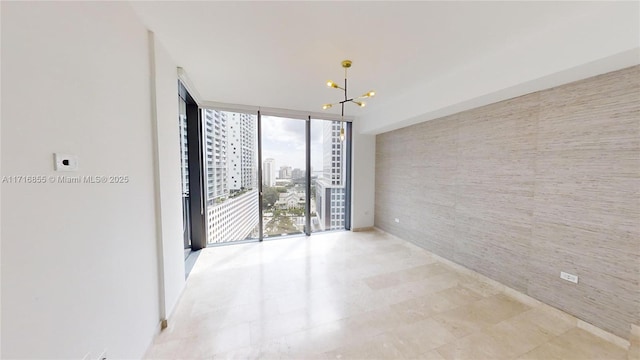 empty room with floor to ceiling windows and a chandelier