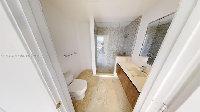 bathroom featuring vanity, hardwood / wood-style floors, toilet, and tiled shower