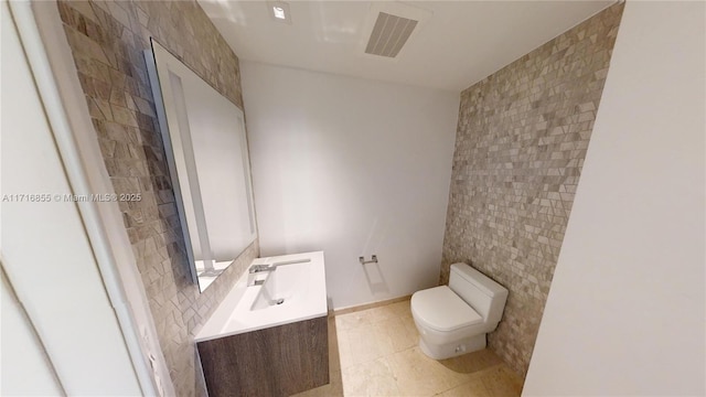 bathroom featuring tile patterned floors, vanity, toilet, and tile walls