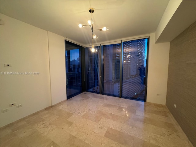 empty room featuring expansive windows and an inviting chandelier