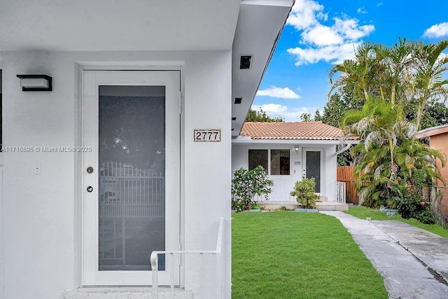 entrance to property featuring a lawn