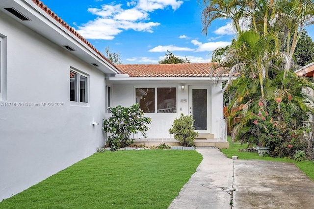 view of exterior entry featuring a yard