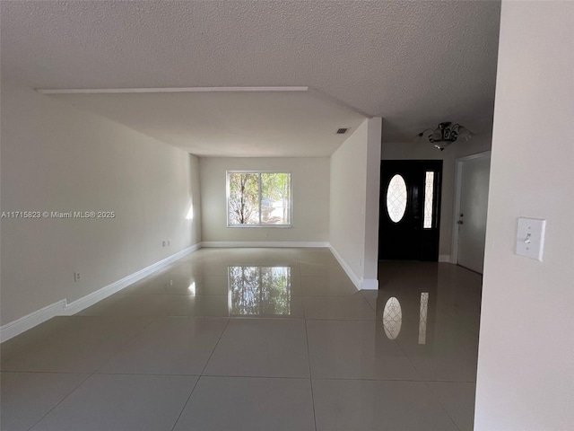 foyer entrance featuring tile patterned flooring and a textured ceiling