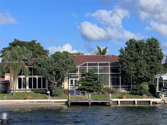 back of house with a water view and a lanai