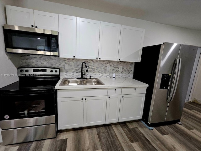 kitchen with appliances with stainless steel finishes, tasteful backsplash, white cabinetry, and sink