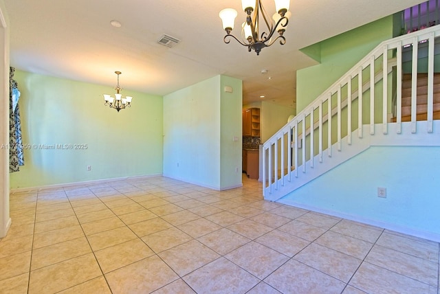 tiled empty room featuring a chandelier