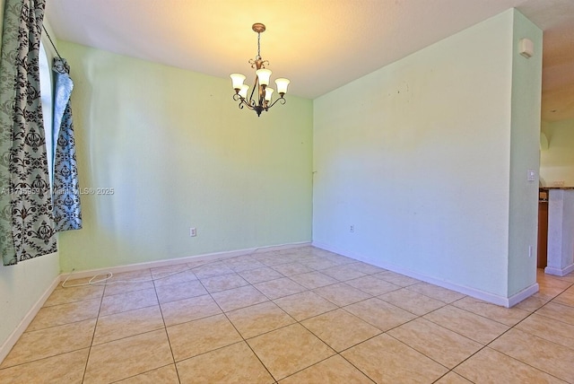 unfurnished room with an inviting chandelier and light tile patterned floors