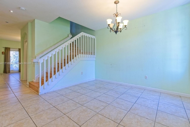 spare room with an inviting chandelier and light tile patterned floors