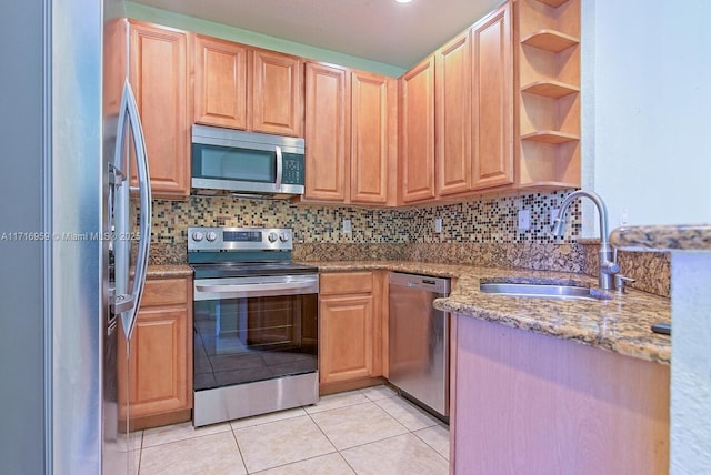 kitchen with stainless steel appliances, light stone countertops, decorative backsplash, and sink