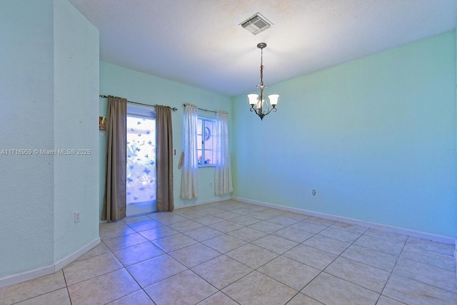 unfurnished room with an inviting chandelier and light tile patterned floors