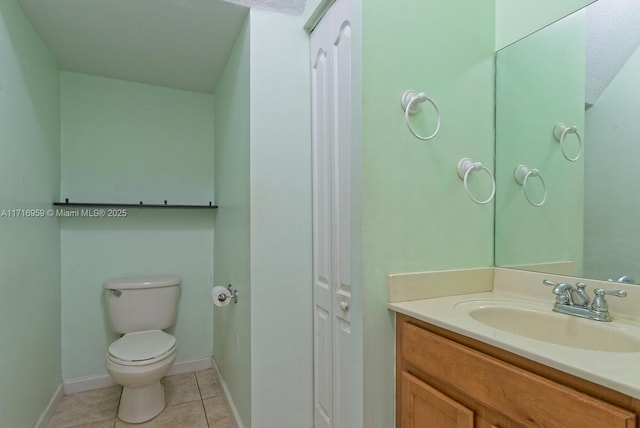 bathroom with tile patterned flooring, vanity, and toilet