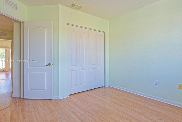 unfurnished bedroom featuring a closet and light hardwood / wood-style floors