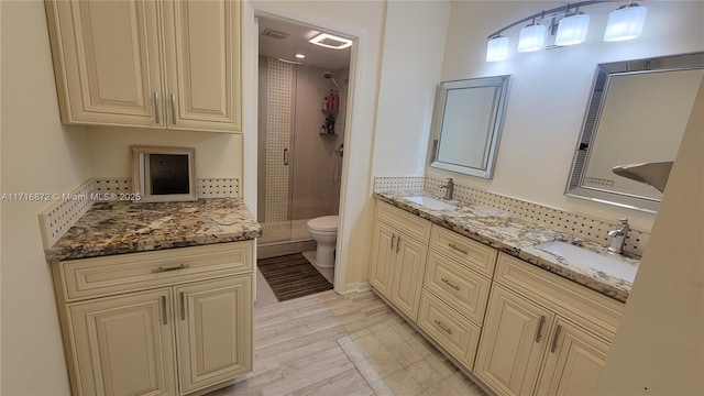 bathroom with hardwood / wood-style floors, vanity, decorative backsplash, toilet, and walk in shower