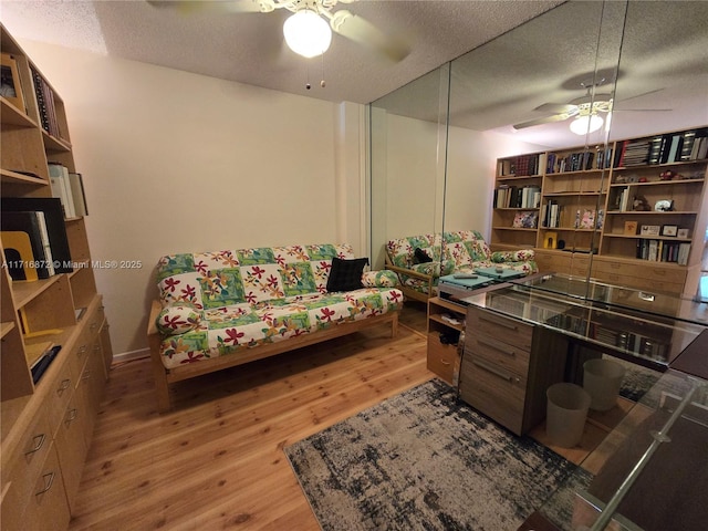 interior space featuring ceiling fan, a textured ceiling, and light wood-type flooring