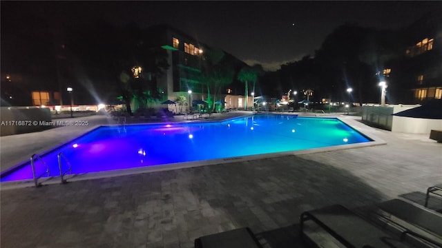 pool at twilight with a patio