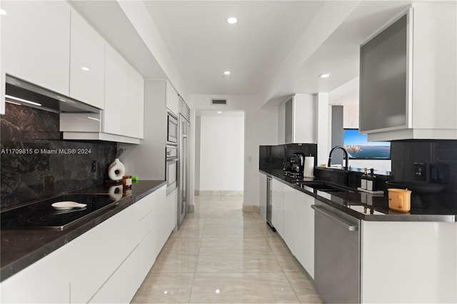 kitchen featuring white cabinets, decorative backsplash, sink, and appliances with stainless steel finishes