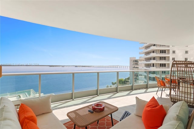 balcony with an outdoor living space and a water view