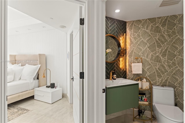 bathroom with tile patterned floors, vanity, toilet, and tile walls