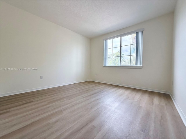 unfurnished room featuring light hardwood / wood-style floors and a textured ceiling