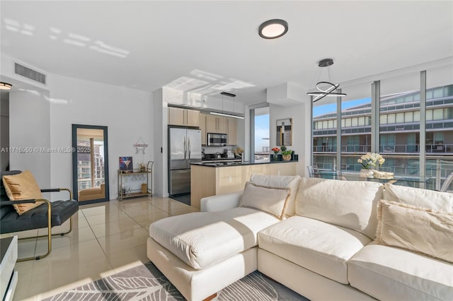 living area with light tile patterned floors, visible vents, and plenty of natural light