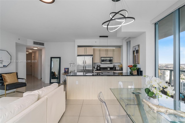 kitchen with dark countertops, light tile patterned floors, appliances with stainless steel finishes, and visible vents