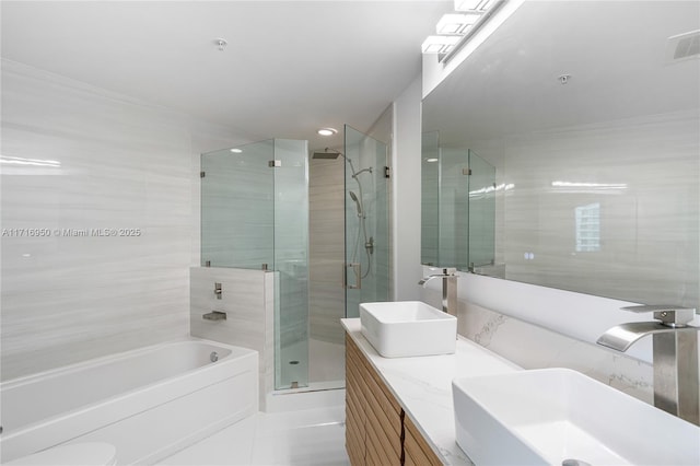 bathroom featuring a sink, visible vents, a stall shower, and double vanity