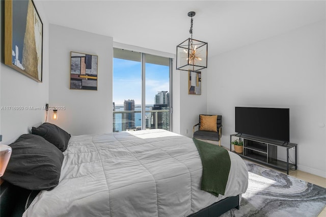 bedroom with access to outside, baseboards, an inviting chandelier, and expansive windows