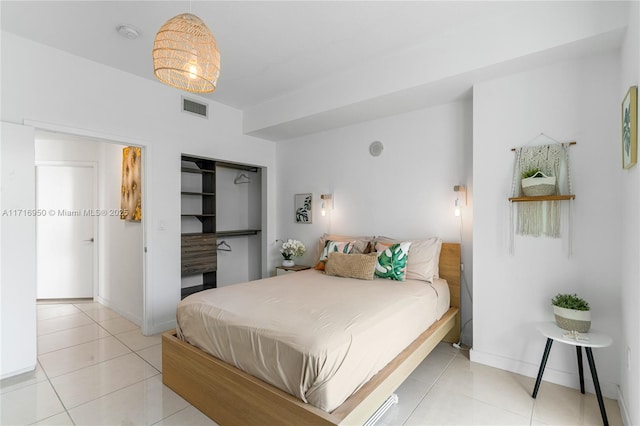 bedroom with light tile patterned floors, visible vents, a closet, and baseboards