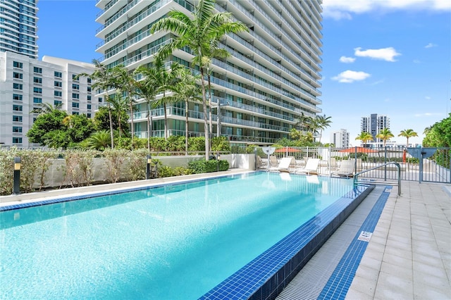 pool with a city view and fence