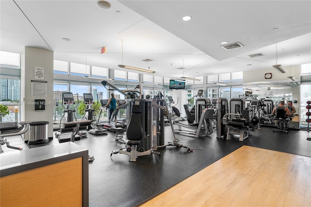 gym with a wealth of natural light, visible vents, and a wall of windows