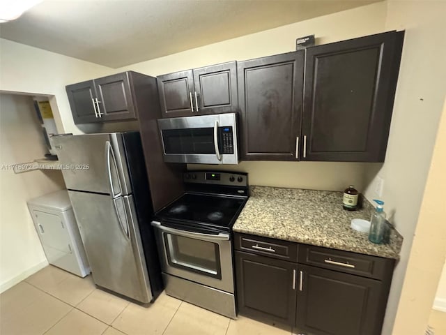 kitchen with light tile patterned flooring, dark brown cabinetry, stainless steel appliances, and washer / clothes dryer