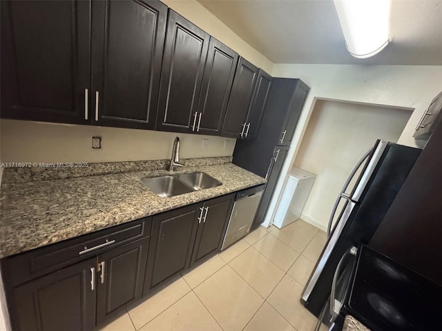 kitchen featuring light stone countertops, sink, light tile patterned floors, and stainless steel dishwasher