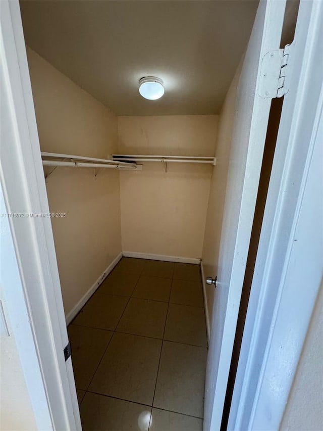 walk in closet featuring dark tile patterned flooring