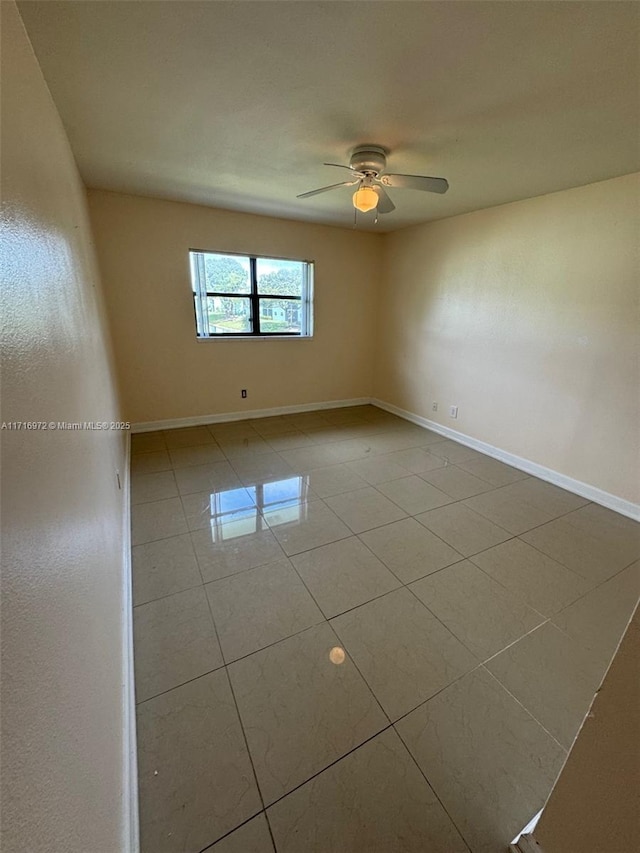 tiled empty room featuring ceiling fan