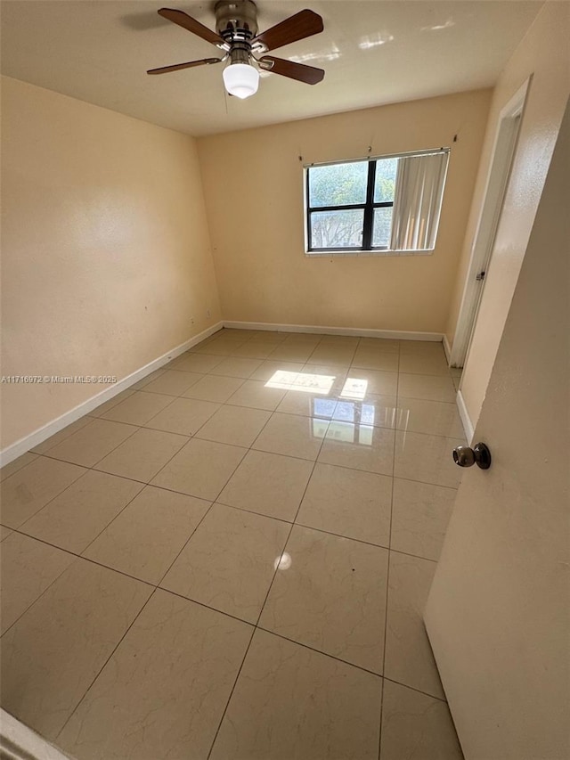 tiled spare room featuring ceiling fan